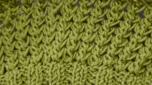 Örgü deseni kalın, yeşil iplik kullanıyor. Örgü kazakları, şapkalar ve diğer örgü eşyalar için detaylar. El Sanatları.