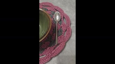 Gri arka planda yuvarlak leylak kaplama örülmüş. İç dekorasyon. Yeşil tabaklar. Desen.