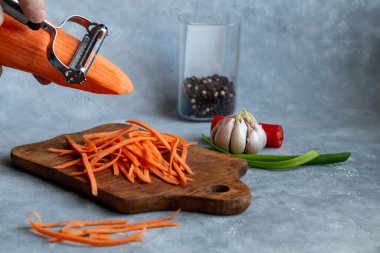 Havuç ve yeşil soğan salatası için malzemeler. Sebze kesme işlemi. Eller çerçevede. Boşluğu kopyala