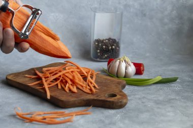 Havuç ve yeşil soğan salatası için malzemeler. Sebze kesme işlemi. Eller çerçevede. Boşluğu kopyala