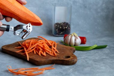 Havuç ve yeşil soğan salatası için malzemeler. Sebze kesme işlemi. Eller çerçevede. Boşluğu kopyala