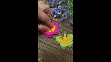 Kelebekler, koyu bir yüzeye örülmüş renkli ipliklerden yapılmıştır. El yapımı. Saç süsü. Boşluğu kopyala