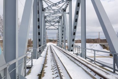 Riga Şehri, Letonya. Kışın eski tren yolu köprüsü ve nehir. 14.02.2021 numaralı seyahat fotoğrafı.