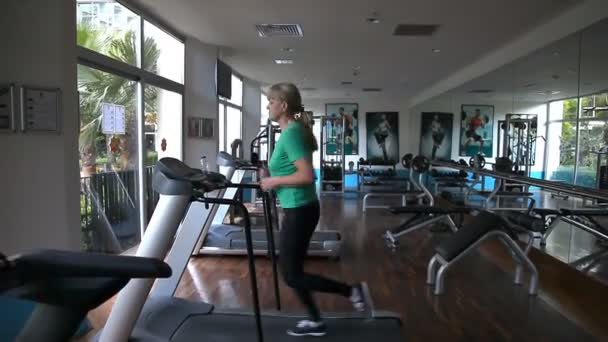 Mujer corriendo en una cinta de correr . — Vídeos de Stock
