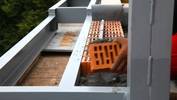 Builder lays bricks on a construction site — Stock Video