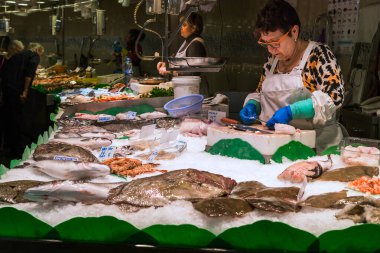 BARCELONA, SPAIN - 10 Mayıs 2017: Bu ünlü Boqueria pazarında satış elemanları ve müşterilerle dolu bir balık tezgahı.