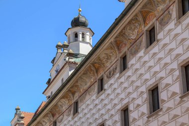 CESKY KRUMLOV, CZECH - 25 Nisan 2012: Bu, saat kulesi ve duvarlarında fresklerle dekore edilmiş eski bir evin ön cephesinin bir parçası.