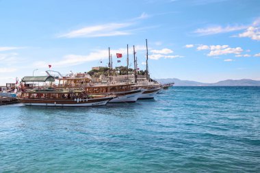 KUSADASI, TURKEY - 2 Haziran 2021 Burası Guverginada kalesindeki eğlence tekneleri için rıhtım..