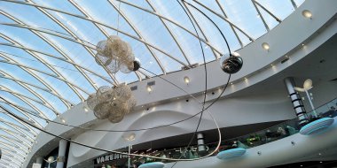 KHARKOV, UKRAINE - MAY 22, 2021: This is an unusual modern chandelier under a glass dome of a modern architecture.