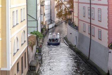 PRAG, CZECH - 26 Ekim 2023 Kampa Adası etrafındaki dar Certovka Kanalı boyunca bir eğlence teknesi geziyor..