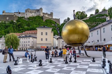 SALZBURG, AUSTRIA - 24 Mayıs 2024: Kimliği belirsiz insanlar Kapitelplatz Meydanı 'nda büyük satranç oynuyorlar.