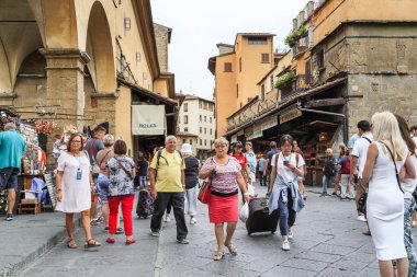 FLORENCE, ITALY - 13 Eylül 2018: Kimliği belirsiz turist ve sakinler Ponte Vecchio 'dan geçerek, sayısız hediyelik eşya dükkanının önünden geçtiler.