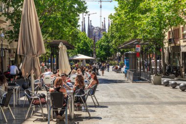 BARCELONA, İspanya - 12 Mayıs 2017: Tanımlanamayan insanlar Sagrada Familia Katedrali 'nin yanındaki Gaudi Bulvarı' nın yaya kesiminde bir kafede dinleniyorlar.