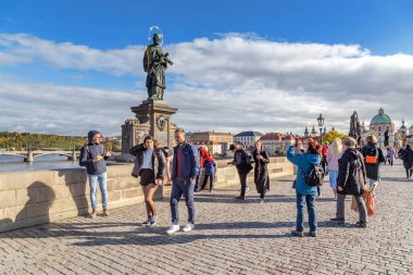 PRAG, CZECH - 26 Ekim 2023: Çok sayıda tanımlanamayan turist, yayaya yerleştirilen azizlerin heykellerini inceliyor.
