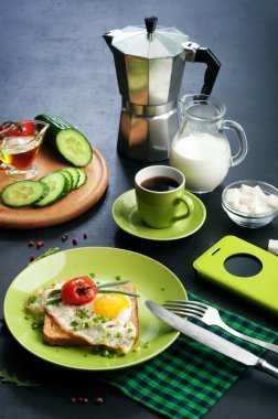 Yararlı ve lezzetli ev yapımı kahvaltı kavramı. Yumurta ve domates, yakın kesilmiş sebzeler, bir fincan kahve, kahve ve diğer kahvaltı öznitelikleri ile sandviç.