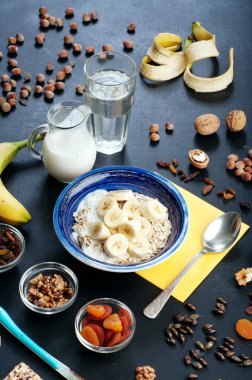 Yulaf ezmesi, meyve, Kuruyemiş ve karanlık bir yüzey üzerinde fındık ile yararlı ve lezzetli bir kahvaltı. Sağlıklı gıda kavramı. Yararlı vejetaryen yemek