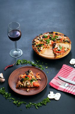 Homemade pizza on a dark board. Italian food. Fast food concept. Place for writing text or recipe