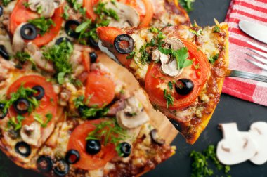 Homemade pizza on a dark board. Italian food. Fast food concept