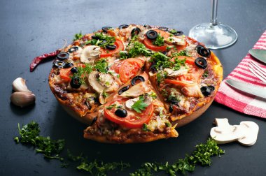 Homemade pizza on a dark board. Italian food. Fast food concept
