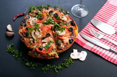 Homemade pizza on a dark board. Italian food. Fast food concept