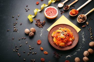 Concept diet food. Light salad with carrot, orange and grapefruit. Next to dried fruits and nuts, which are used in the preparation of a balanced diet. Vegetarian healthy food.