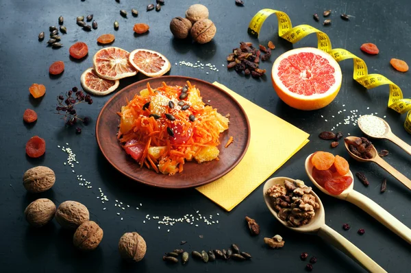 Concepto de dieta de alimentos. Ensalada ligera con zanahoria, naranja y pomelo. Junto a los frutos secos y frutos secos, que se utilizan en la preparación de una dieta equilibrada. Comida vegetariana saludable . — Foto de Stock