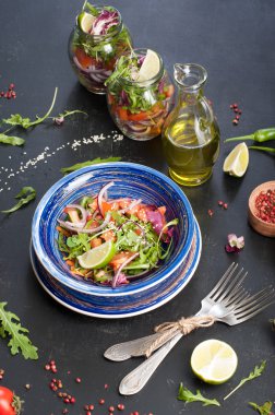 Sağlıklı bir diyet kavramı. Roka, domates, mor soğan ve kireç, seninle bir cam kavanozun içinde çalışmak için yapabileceğiniz hafif salata. Yararlı ve lezzetli yiyecek götürmek.