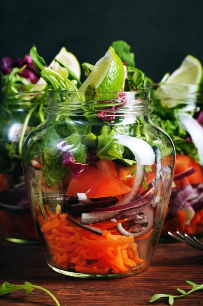 Das Konzept einer gesunden Ernährung. leichter Salat aus Rucola, Tomate, lila Zwiebel und Limette, den man zum Arbeiten in ein Glas mitnehmen kann. Nützliches und schmackhaftes Essen zum Mitnehmen. — Stockfoto