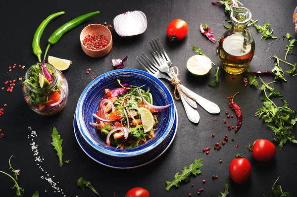 Koncept zdravé stravy. Lehký salát s rukolou, rajčaty, fialové cibule a vápno, které si můžete vzít s sebou do práce do sklenice. Užitečné a chutné odnést jídlo. — Stock fotografie