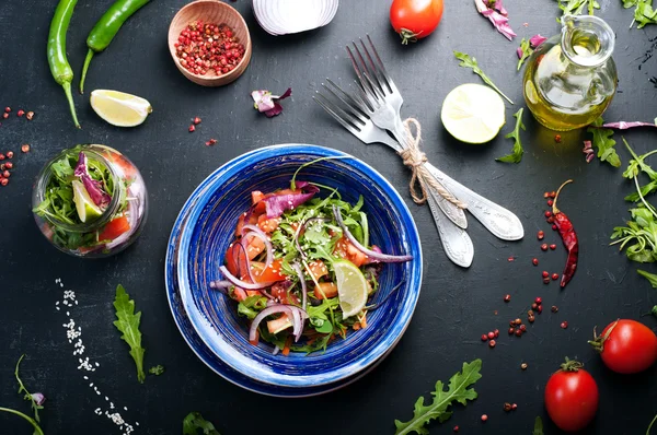 Il concetto di una dieta sana. Insalata leggera di rucola, pomodoro, cipolla viola e lime, che puoi portare con te per lavorare in un barattolo di vetro. Cibo da asporto utile e gustoso . — Foto Stock