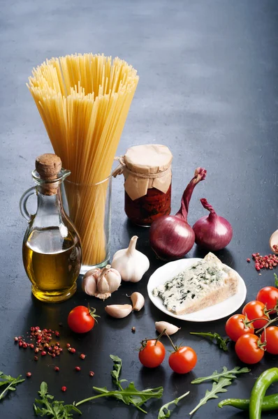 Conceptul alimentar italian. Ingrediente pentru gătit paste, cum ar fi paste, ceapă, roșii, ulei de măsline, carne de vită măcinată, frunze de busuioc și brânză pe placa întunecată. Locul pentru scrierea textului — Fotografie, imagine de stoc