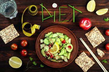 Concept diet food. Seasonal salad of radish and cucumber, next to which is a dietary bread, chopsticks, apples, tomatoes, a glass of water. Vegan concept. East style clipart