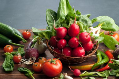 Taze sulu sebze ve otlar, turp, ıspanak, domates ve acı biber gibi kahverengi bir ahşap tahta üzerinde. Vegan kavramı. Sebze arka planı. Metin için alan