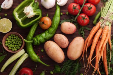 Taze sulu sebze domates, biber, salatalık, patates, bebek havuç ve yeşil bezelye kahverengi ahşap tahtası gibi. Vegan kavramı. Sebze arka plan