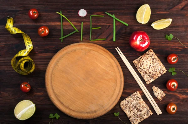 Concept diet food. The word diet, inlaid pieces of onions feathers. Beside cutting board, on which you can put any dietary dish, measuring tape, chopsticks. East style. Place for writing text. Vegan, vegetarian concept — Stock Photo, Image