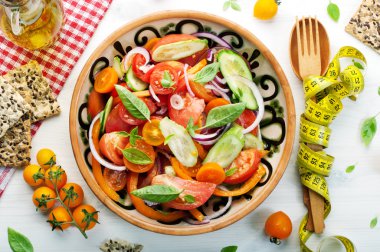 Diyet sebze salatası, domates, salatalık, biber, mor soğan ve fesleğen tabak. Kavram diyet yiyecek. Az yağlı vegan diyet