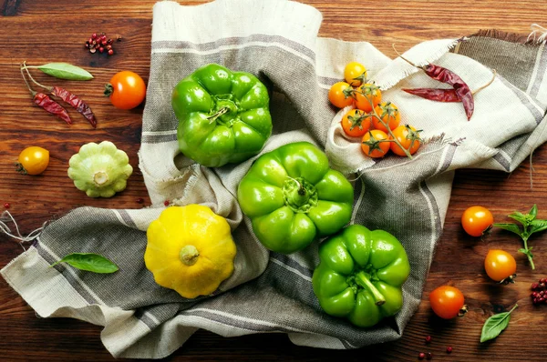 Frische saftige grüne Paprika, Kürbis und gelbe Tomaten auf braunem Holzgrund. Farm Food Konzept. Gemüse über (Hintergrund)) — Stockfoto