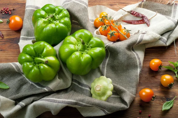 Frische saftige grüne Paprika, Kürbis und gelbe Tomaten auf braunem Holzgrund. Farm Food Konzept. Gemüse über (Hintergrund)) — Stockfoto