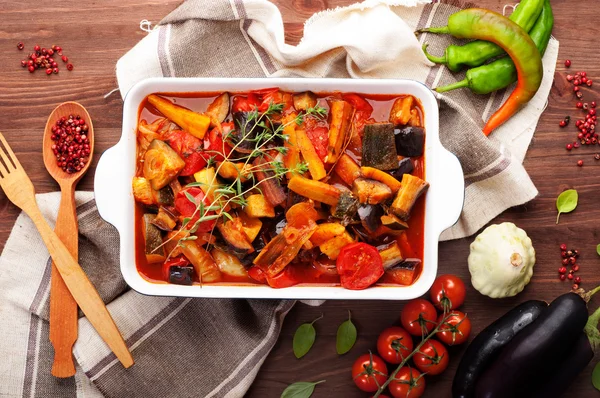 Guisado fresco 'Ratatouille' caseiro. Fatias de berinjela, abobrinha, cenouras, cebolas, tomates, aromatizados com um raminho de salgado. Dieta vegetariana — Fotografia de Stock