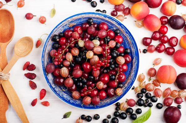 Platillo azul con bayas frescas jugosas como cerezas, grosellas, fresas, grosellas negras y rojas. Concepto de dieta de alimentos. Fondo de bayas de verano (fondo de pantalla ) — Foto de Stock