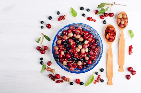 Platillo azul con bayas frescas jugosas como cerezas, grosellas, fresas, grosellas negras y rojas. Concepto de dieta de alimentos. Fondo de bayas de verano (fondo de pantalla ) — Foto de Stock