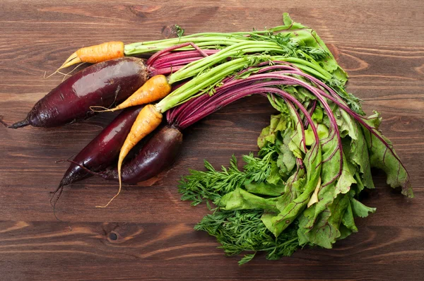 Concepto vegano. Cosecha. Verduras frescas jugosas, como zanahorias y remolachas con un fondo de madera marrón. Las verduras frescas orgánicas bajas en calorías —  Fotos de Stock