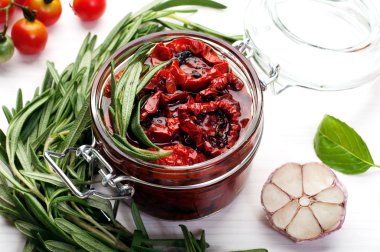 Beyaz bir arka plan üzerinde cam bir kavanozda güneşte kurutulmuş domates. Vejetaryen, vegan konsepti. Akdeniz ve İtalyan mutfağı