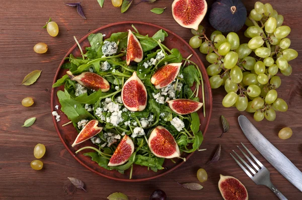 Light summer salad with arugula, figs and blue cheese. Low-calorie nutritious ready-made meal. Autumn menu