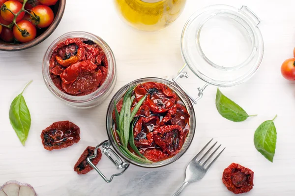 Tomates secados al sol en un frasco de vidrio sobre un fondo blanco. Vegetariano, concepto vegano. Cocina mediterránea e italiana — Foto de Stock