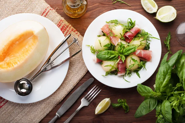 Salade à la roquette, boules de melon et jambon sur fond de bois brun. Cuisine espagnole exquise. Des tapas. Salade maison — Photo