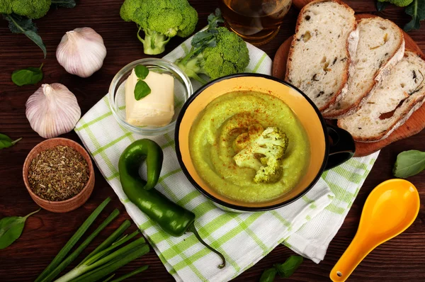 Cream of broccoli soup. Beside the ingredients for the soup, such as broccoli, peppers, onions. The concept of dietary vegetarian food — Stock Image Cream of broccoli soup. Beside the ingredients for the soup, such as broccoli, peppers, onions. The concept of dietary vegetarian food Royalty Free Stock Photos