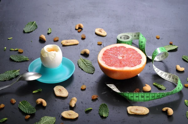 The concept of the classical diet with grapefruit and egg on a black background. — Stok fotoğraf