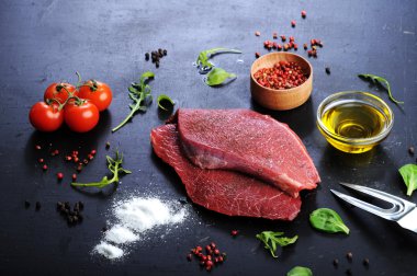 Kara tahta üzerinde ham sığır eti biftek. Arka ışık. Eti biftek yemek için hazırlanıyor kavramı