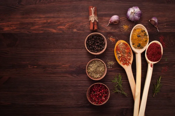 Varias especias para el pilaf y la carne sobre un fondo de madera oscura. Lugar para escribir texto o receta —  Fotos de Stock